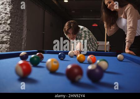 Young people enjoying playing billiard together Stock Photo