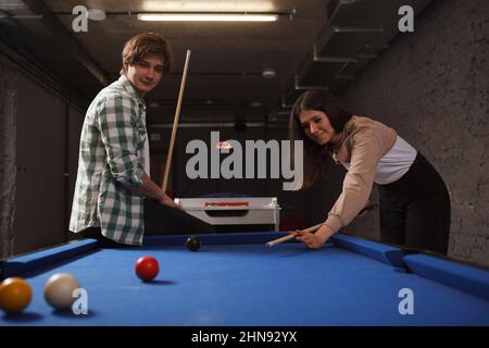 Friends enjoying playing billiard on a pool table Stock Photo