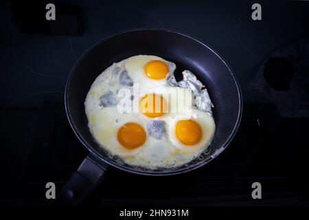 Fried eggs cooked on an induction hobb Stock Photo