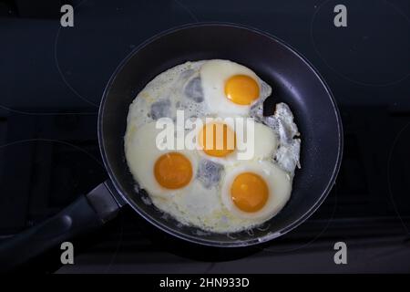 Fried eggs cooked on an induction hobb Stock Photo