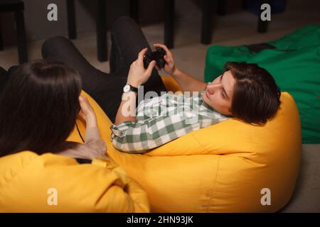 Young man looking at his girlfriend while playing video games together Stock Photo