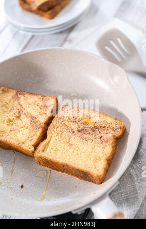 Frying french toast in a nonstick frying pan. Stock Photo