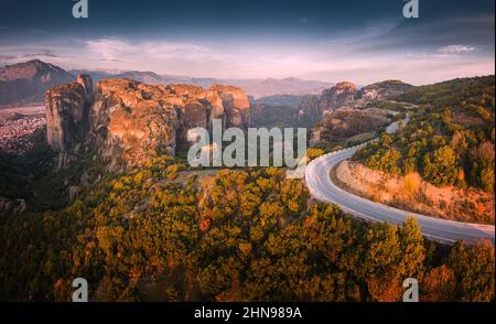 Inspirational aerial panoramic view of iconic and majestic Meteora monastery travel destination and winding road in Greece. Discover new tourist exper Stock Photo