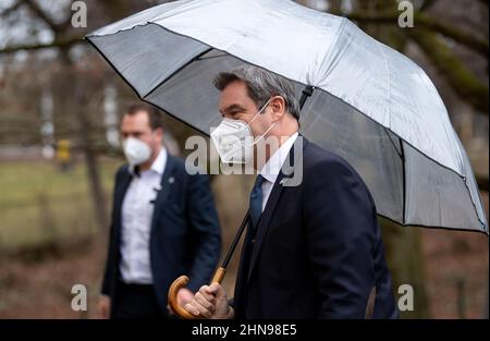 Munich, Germany. 15th Feb, 2022. Markus Söder (CSU), Prime Minister of Bavaria, arrives under an umbrella at the press conference after the cabinet meeting. Credit: Sven Hoppe/dpa/Alamy Live News Stock Photo