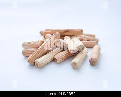 Wooden dowels for assembling furniture on white background. Front view. Selective focus Stock Photo
