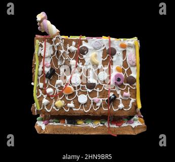A Gingerbread house against a black background Stock Photo