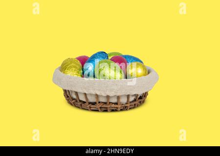 Basket with colorful wrapped Easter egss. Stock Photo