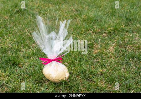 White chocolate Easter egg in the garden. Stock Photo