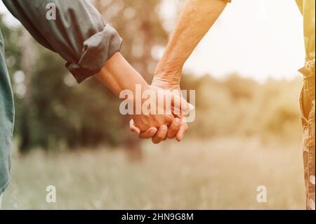 happy senior couple holding hands. hands of man and woman hold each other. romance and love and support in elderly family. faceless husband and wife t Stock Photo