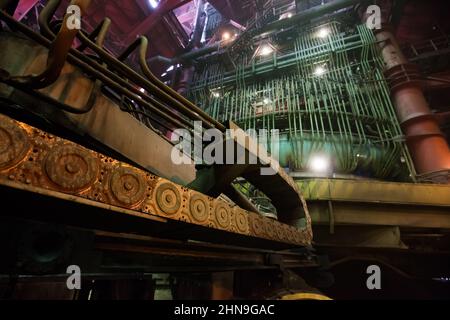 Smelter workshop. Foreground in focus. Electric arc furnace (blast furnace) on background out-of-focus. Wide-angle lens view. Stock Photo