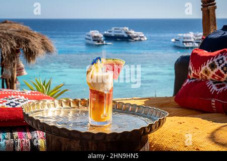 Bright Healthy Berries Cocktails on Table Beach with Blue Sea on Background. Concept of Summer Vacations at Maldives or Caribbean Resorts. Fresh Fruit Stock Photo