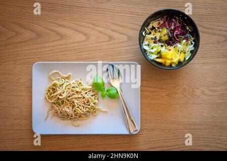 handmade pasta with pesto decorated with basil leaves including fresh salad in bowl Stock Photo