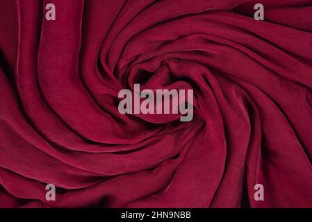 Soft smooth burgundy silk fabric background. Fabric texture. Stock Photo