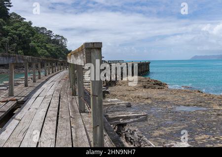 Remains of old wharf or jetty stretching out from land at Hicks Bay on East Coast North Island New Zealand. Stock Photo