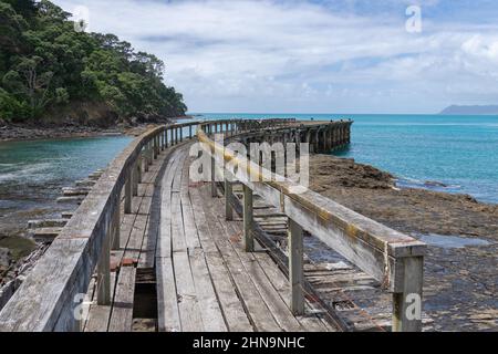 Remains of old wharf or jetty stretching out from land at Hicks Bay on East Coast North Island New Zealand. Stock Photo