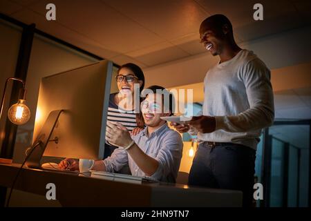Cracking codes is what makes them happy. Shot of computer programmers working together late in the office. Stock Photo
