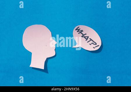 Paper Human face with What Question Mark on speech bubble isolated on blue background. Conceptual images showing to express doubt or uncertainty about Stock Photo