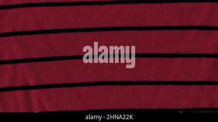 Magneta knitted background with copy space. Fabric poppy red colored colored texture with black stripes. Stock Photo