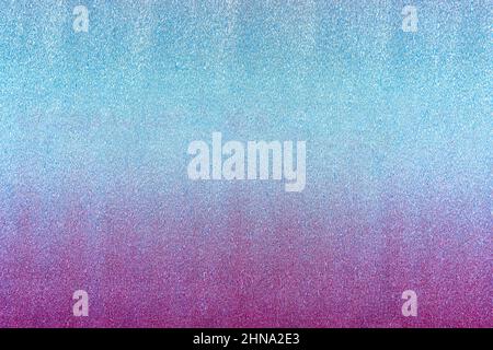 Texture of rough shiny metallic crepe paper or foil colored in pink to blue intense neon gradient. Abstract bright background with large copy space. H Stock Photo