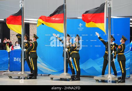 Peking, China. 15th Feb, 2022. Bobsleigh: Olympics, two-man bobsleigh, men, 4th run at Yanqing National Sliding Centre, German flags are hoisted at the award ceremony. Credit: Michael Kappeler/dpa/Alamy Live News Stock Photo