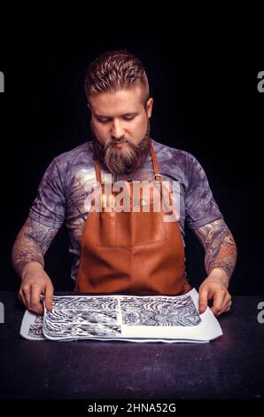 Leather Professional performs leather working for a new product in the work area Stock Photo