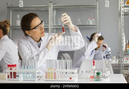 Portrait of a focused female technician conducting a blood sample study in a research laboratory. Stock Photo