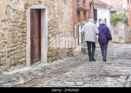 A senior couple walking on the streets of an ancient city Motovun on Istria in Croatia, Europe. Stock Photo