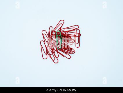 Multi coloured, red and green paper clips in a pile on a plain white background. Stock Photo