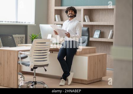 Young curly-haired manager feeling busy at work Stock Photo