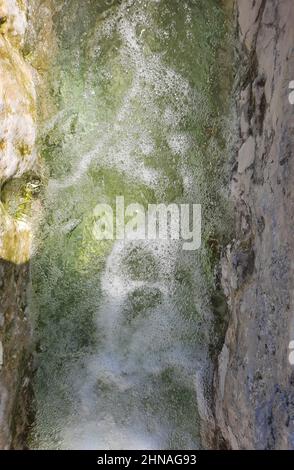 Background of mineral water flow from a spring in Pamukkale, Turkey. Water with a high content of limestone. Stock Photo