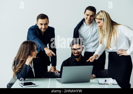 Young coach teaching employees group analyzing online project explaining business strategy speaking training diverse corporate team with laptop using Stock Photo