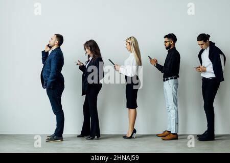 Businessmen on a line using their cellphones Stock Photo