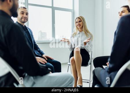 Diverse colleagues brainstorm at conference table discuss project at meeting, Focused businesspeople talk negotiating in office at briefing. Business Stock Photo