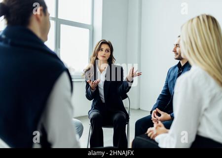 Diverse colleagues brainstorm at conference table discuss project at meeting, Focused businesspeople talk negotiating in office at briefing. Business Stock Photo
