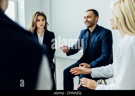 Diverse colleagues brainstorm at conference table discuss project at meeting, Focused businesspeople talk negotiating in office at briefing. Business Stock Photo