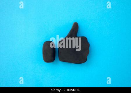 Thumbs up symbol. 3d icon shape of black thumb up sign on blue background. Concept of success and approval. Positive Feedback. Stock Photo