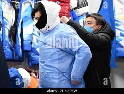 (220215) -- BEIJING, Feb. 15, 2022 (Xinhua) -- Huai Wei (L) wears protective gears with the help of his teammate at National Alpine Skiing Centre in Yanqing District, Beijing, capital of China, Feb. 14, 2022. Huai Wei, an associate chief physician from the Emergency Department of Peking University Third Hospital, along with four other colleagues, currently renders his service as a skiing doctor for the alpine skiing event of the Beijing 2022 Olympic Winter Games at National Alpine Skiing Centre in Zhangjiakou of Hebei Province. Huai is stationed to provide immediate medical help to any at Stock Photo