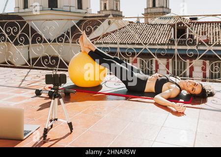 Young sporty fit woman coach doing online lessons through video call on her mobile phone Streaming lessons and healthcare lifestyle concept Stock Photo