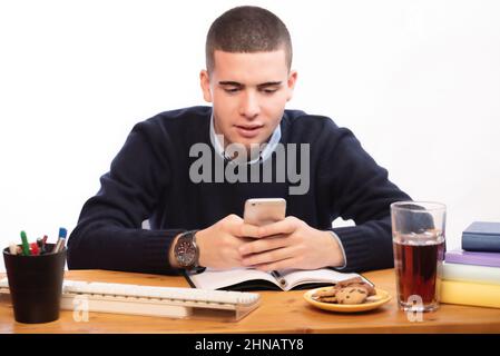 young men writing in a book and working in the computer at home, online school Stock Photo