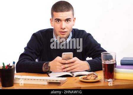 young men writing in a book and working in the computer at home, online school Stock Photo