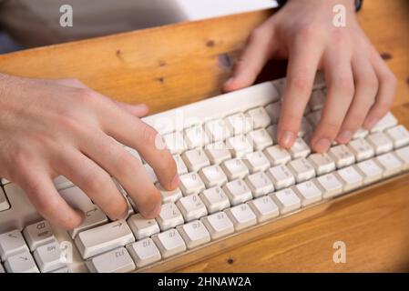 two hands writing in a computer keyboard, working in the computer at home Stock Photo