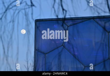 Beijing, China. 15th Feb, 2022. Photo taken on Feb. 15, 2022 shows the moon and the National Aquatics Centre in Beijing, capital of China, Feb. 15, 2022. Credit: Huang Xiaobang/Xinhua/Alamy Live News Stock Photo