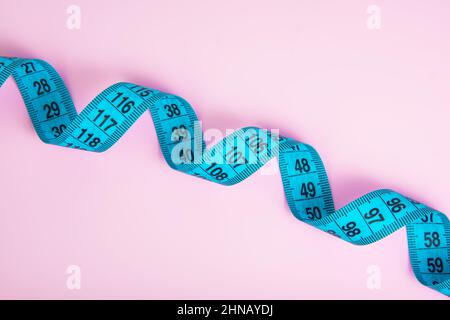 Bright colorful tape measure on pink background with copyspace Stock Photo