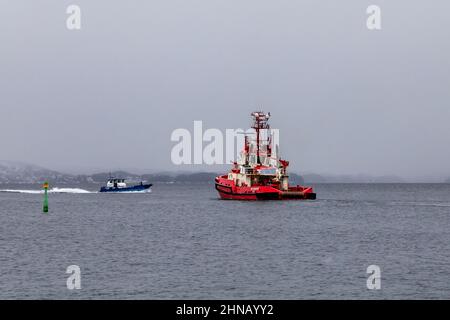 Tug boat BB Coaster at Byfjorden,  departing from the port of Bergen, Norway. In background is the harbour authority's service vessel Sydnes. Stock Photo