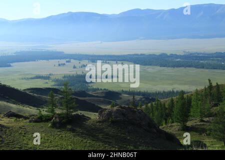 Chuya river valley in Kurai steppe in Altai with rocks, trees, river and North Chuisky ridge at dawn in summer Stock Photo