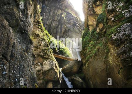 Waterfall in Monk's Gorge among huge cliffs in backlight Stock Photo