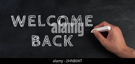 The words welcome back are standing on a chalkboard, reopen post covid-19 pandemic, back to normal, community Stock Photo