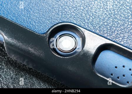 Tablet camera on the back of a mobile digital electronic device in a blue leather case. Close-up. Copy space. Macro shot Stock Photo