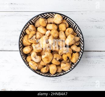 Canjica, hominy or white corn popcorn, sweet popcorn in a bowl over wooden table. Stock Photo