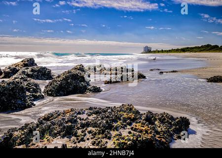 Limestone boulders and the beach at Red Reef Park in Boca Raton Florida Stock Photo